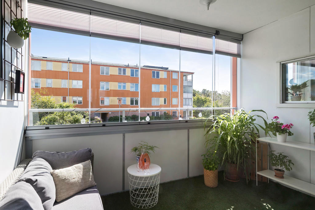 Generös och soldränkt inglasad balkong med välskötta innergårdar att blicka ut över.