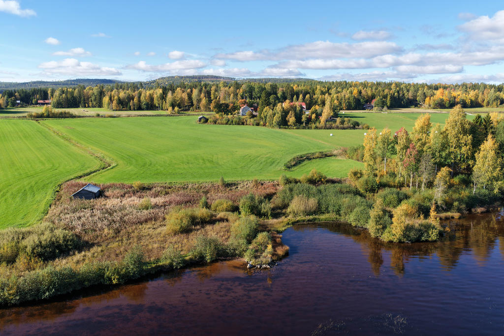 Vy från Orsjön och Ljusnan mot fastigheten.