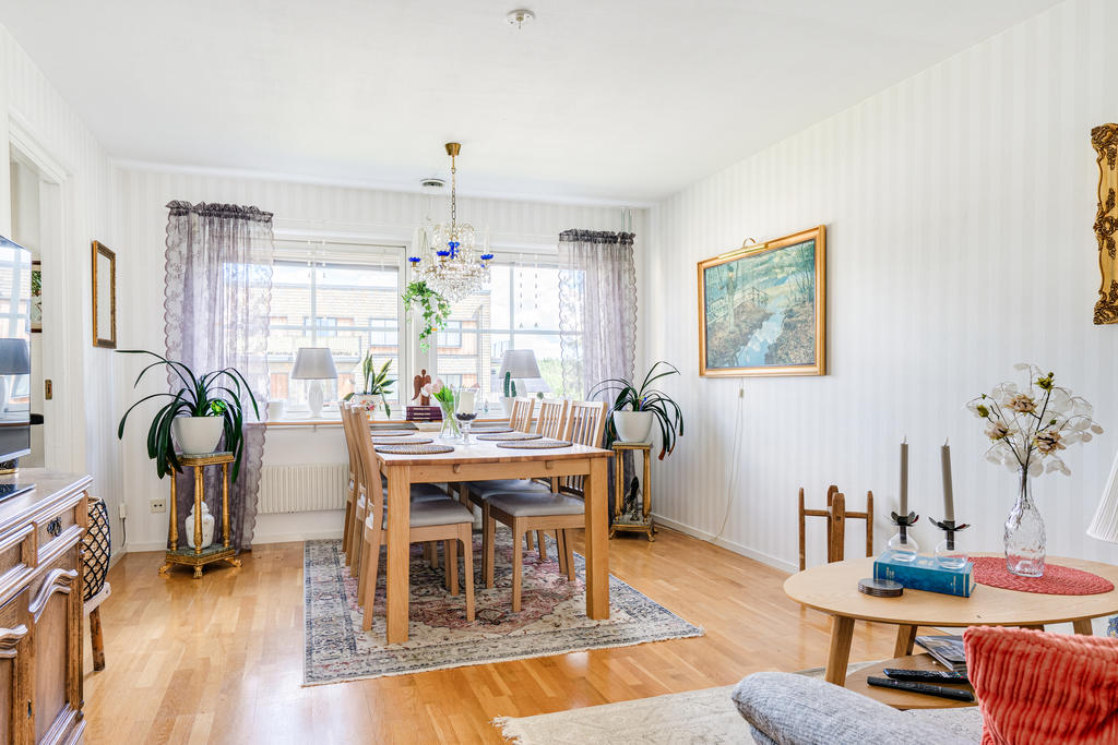 Hemtrevligt vardagsrum med fin ljusinsläpp och plats för matbord.