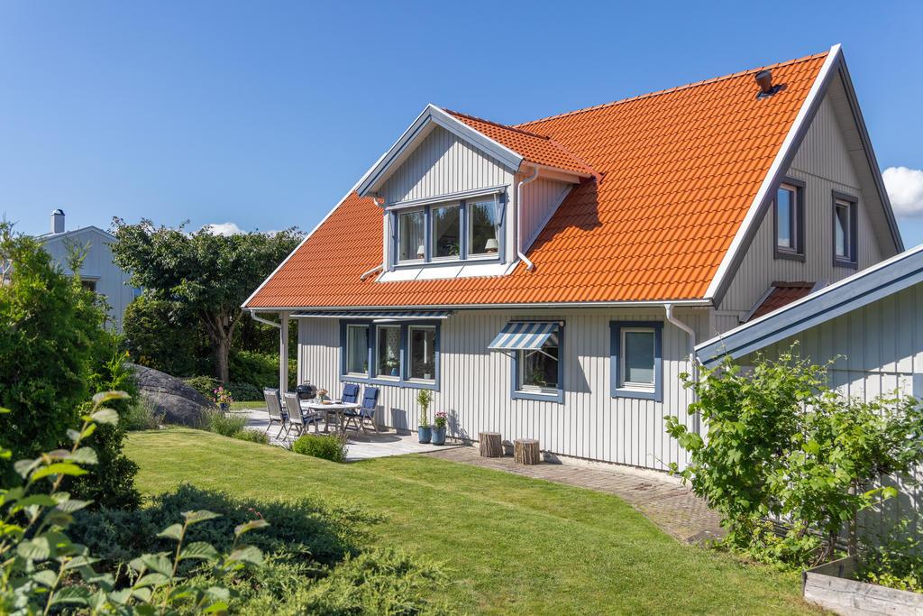 En tomt som kombinerar lekvänliga gräsytor med naturliga inslag av berg och grönska – perfekt för både stora och små
