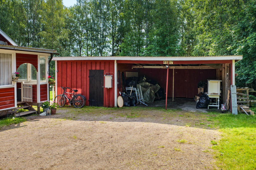 Dubbel carport i enklare uthus med förvaring och hundgård i bakkant. 