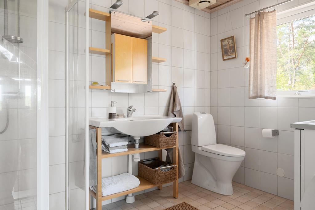 Välplanerat badrum med praktisk tvättdel.