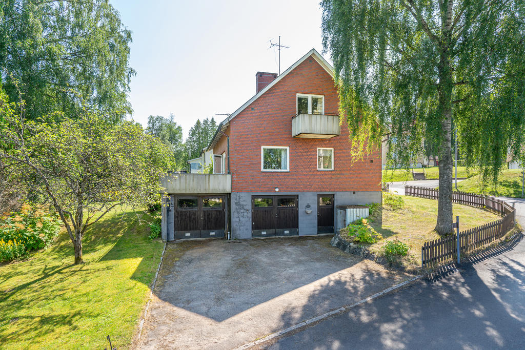 Huset erbjuder asfalterad uppfart med garage i källarplan.