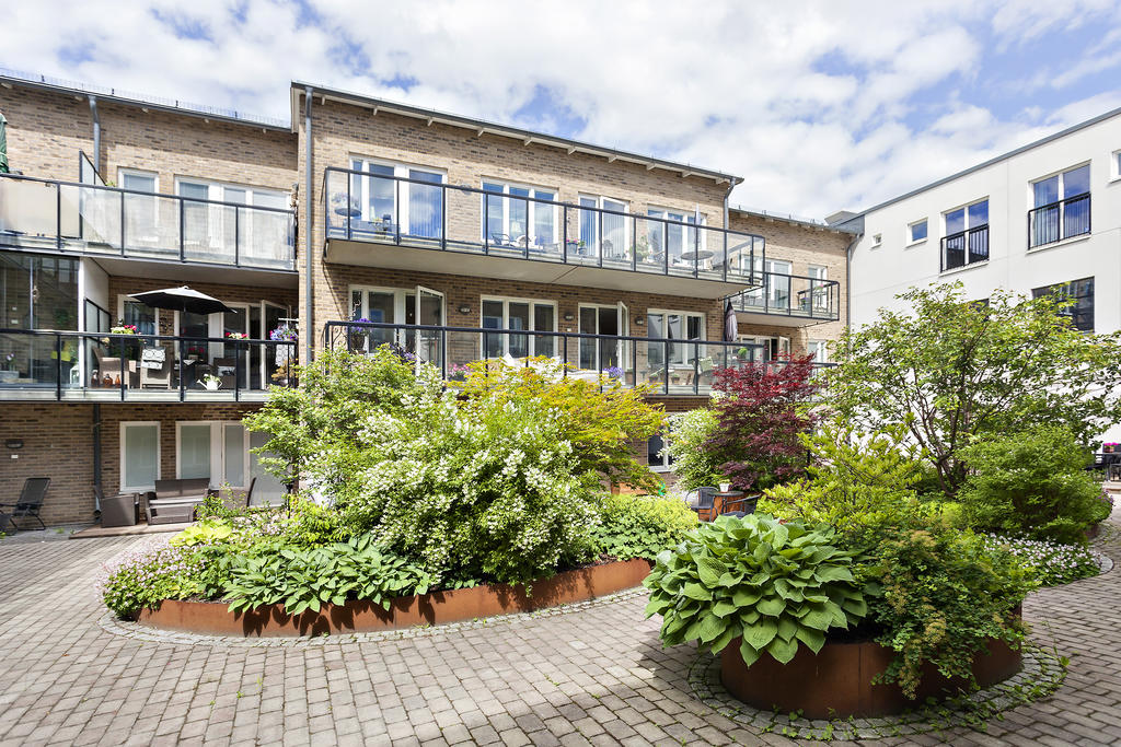 Välskött innergård med stenläggningar och fin grönska