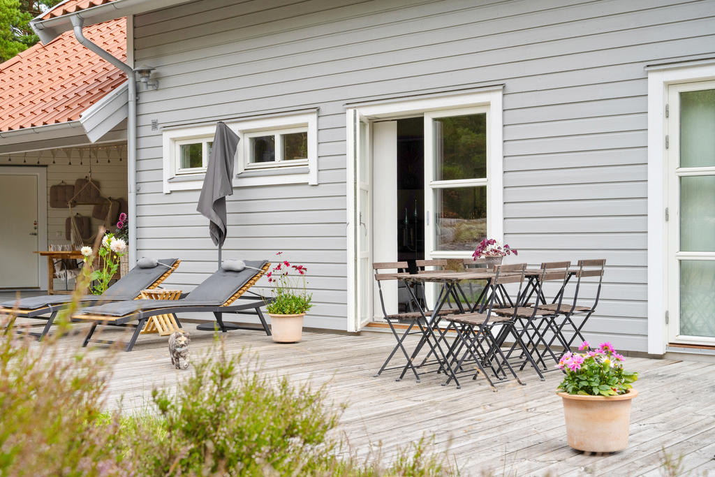 Terrass på baksidan huset med plats för både solstolar och matplats.