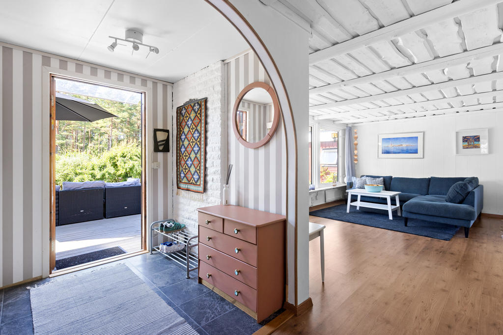 Välkomnande hall med plats för avhängning och praktisk förvaring. Härifrån nås bostadens samtliga rum på ett funktionellt och lättillgängligt sätt.