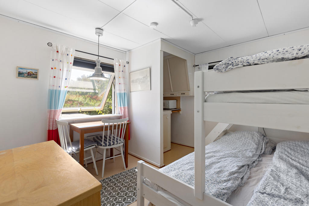 Ett fullt utrustat gästhus med badrum, toalett, trinettkök och sovplats ger extra komfort och flexibilitet för familj och gäster.