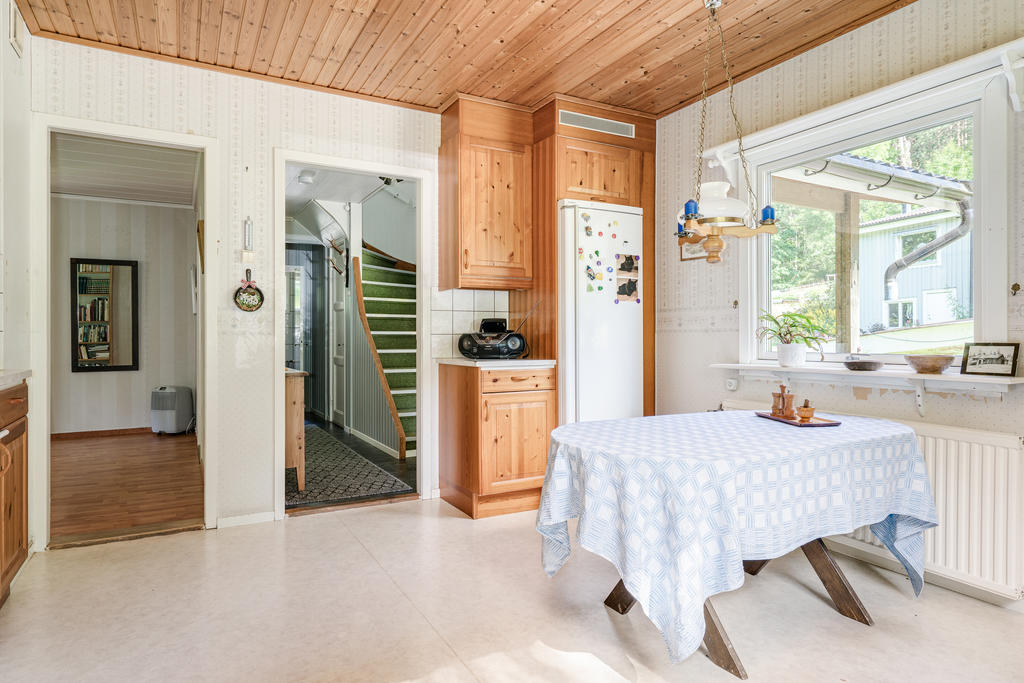 Praktiskt kök med fint ljusinsläpp, träfärgade köksluckor och plats för separat matplats. 