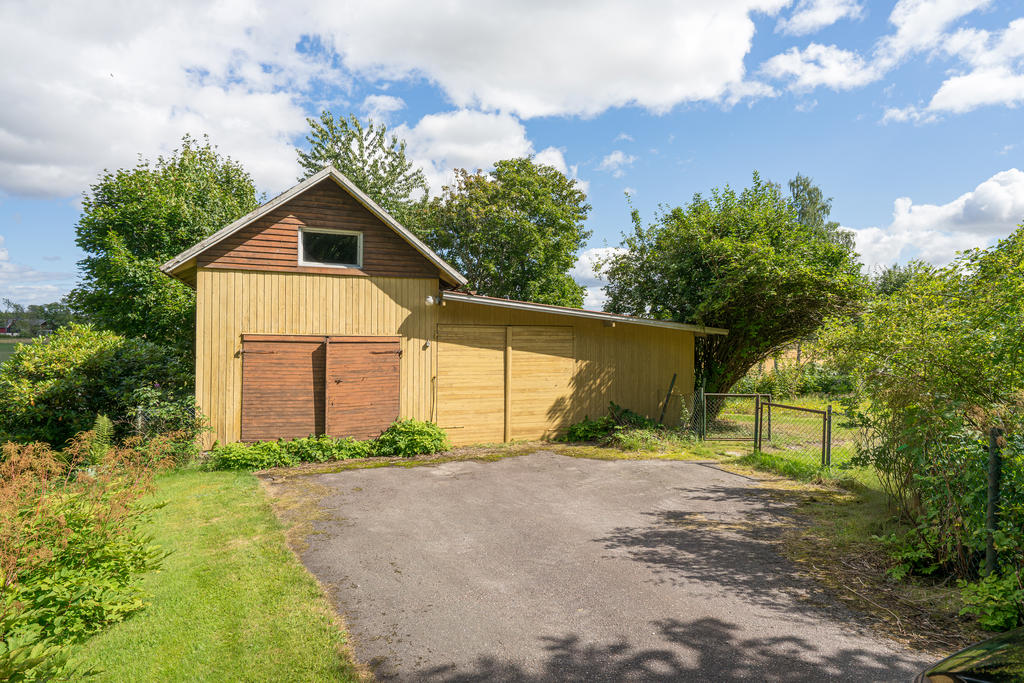 Asfalterad uppfart med carport och förrådsbyggnad finns på tomten. 