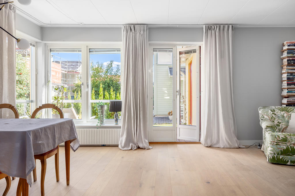 Härligt ljust vardagsrum med utgång till altanen på andra sidan