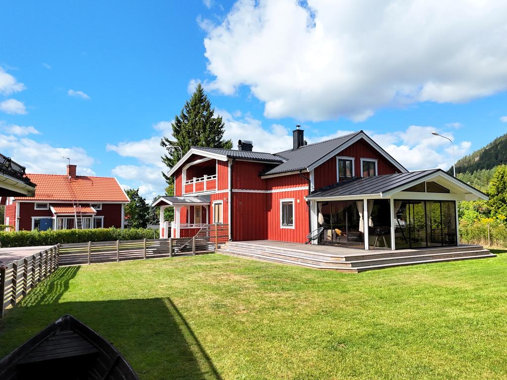 Inglasat uterum och altan mot den inhägnade trädgården