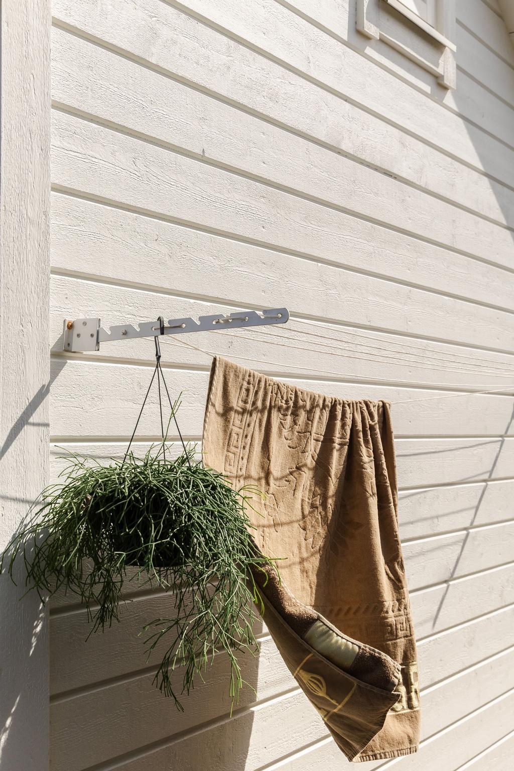 Små, genomtänkta detaljer och grönska ger den ljusa fasaden ett extra välkomnande uttryck.