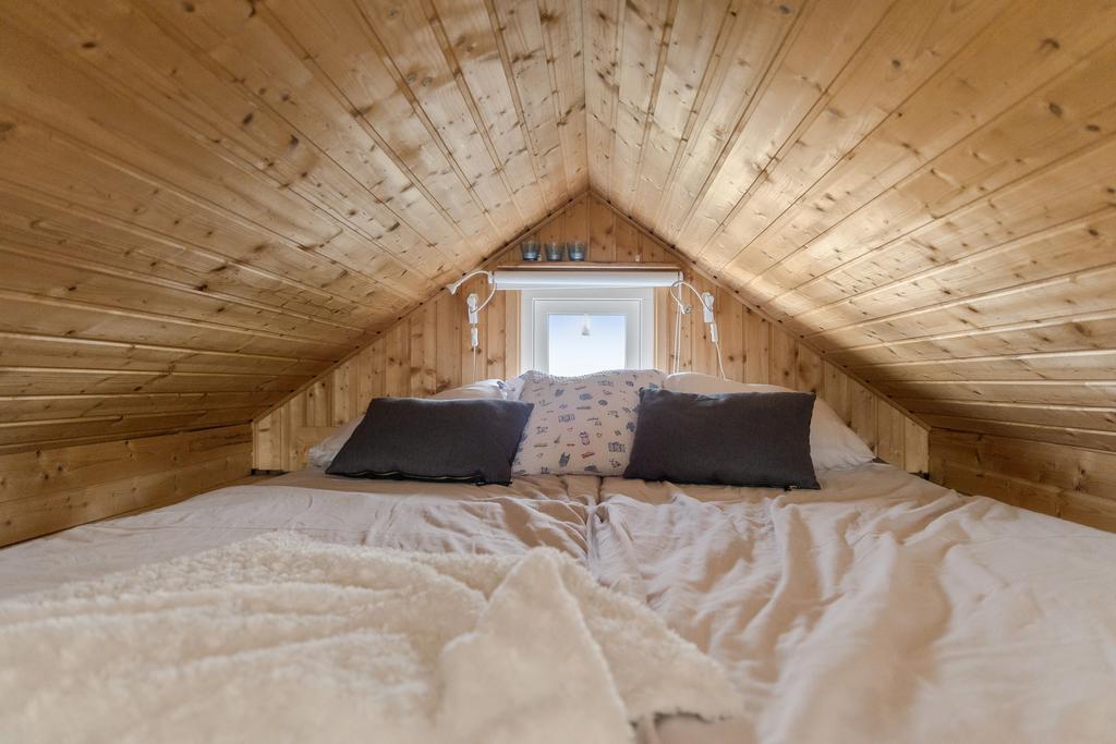 Under det vackra trätaket väntar ett ombonat sovloft med plats för dubbelsäng. En mysig och avskild plats att krypa upp på efter en lång sommardag.