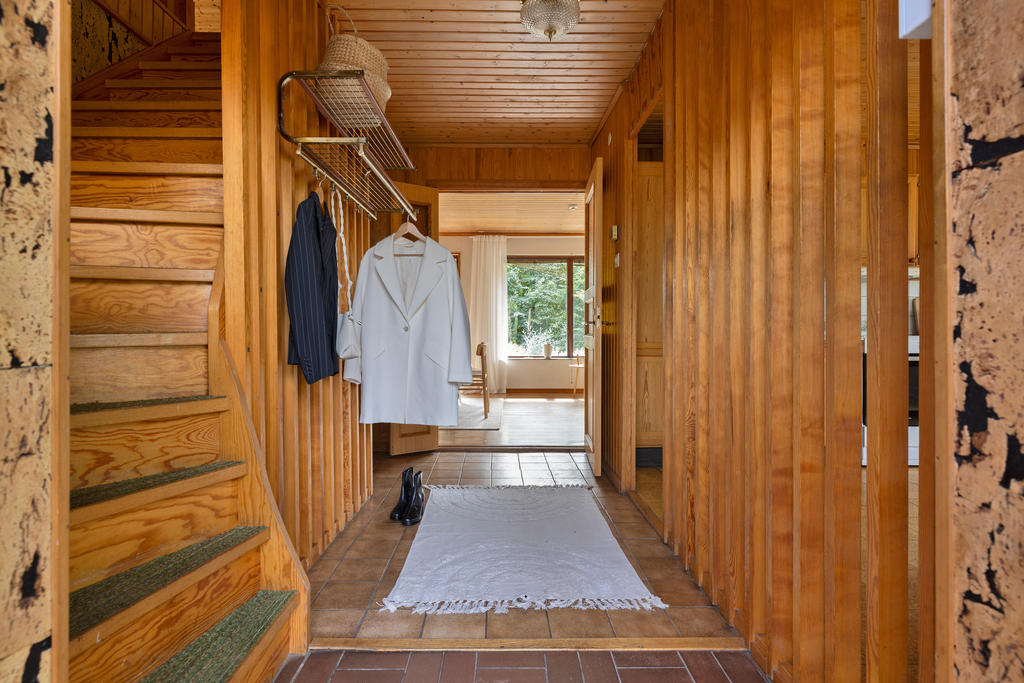 Välkomnande hall med tidstypisk spaljé som ger karaktär åt entrén.