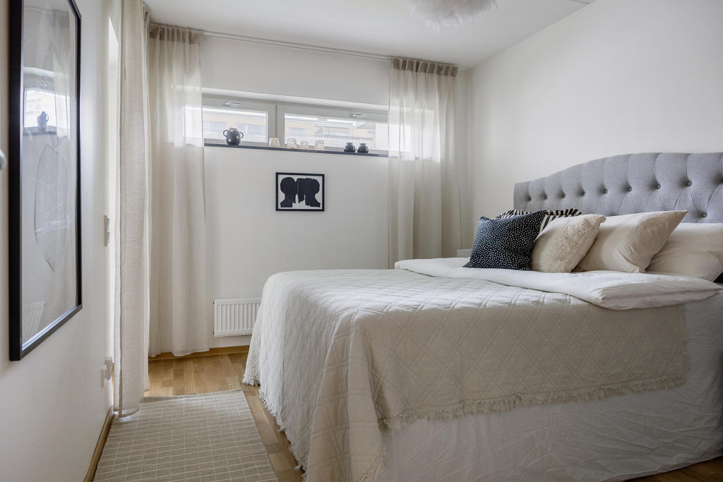 Sovrum ett med skjutdörrsgarderober och utgång till en av bostadens uteplatser