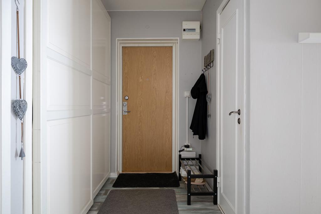 Hall med plats för avhängning. Stor skjutdörrsgarderob längsmed hela ena väggen