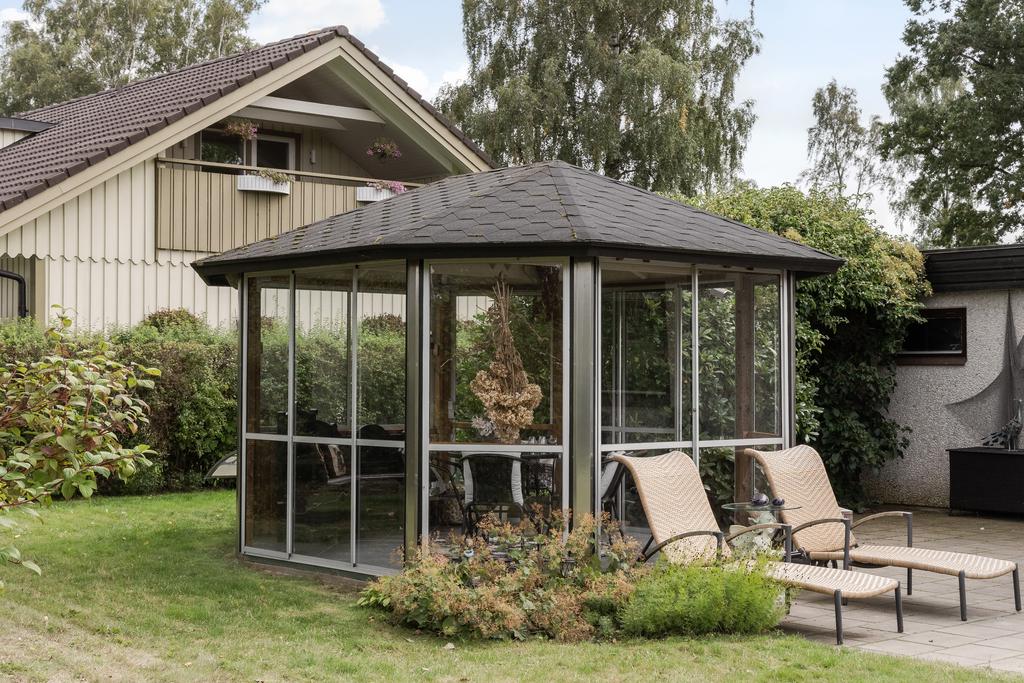 I anslutning till lusthuset finns en stenlagd uteplats med plats för ytterligare sittgrupp.