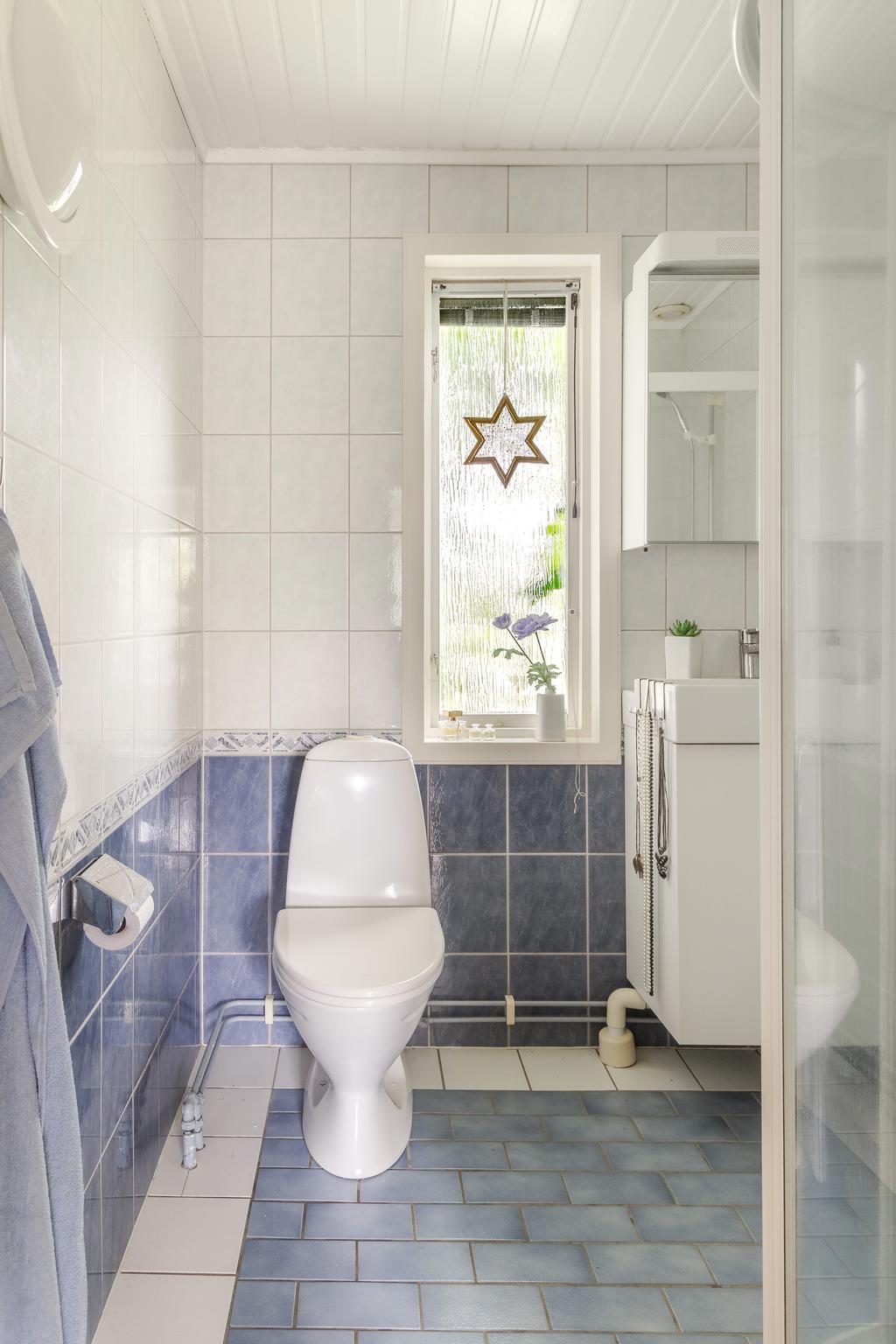 Badrummet är utrustat med dusch, wc och handfat i en praktisk utformning.