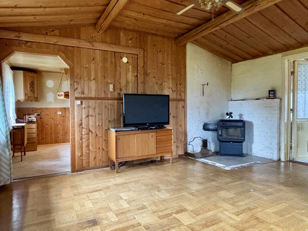 Vardagsrum med kamin och utgång till takad och delvis inglasad altan.