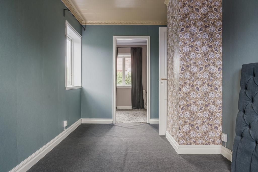 Sovrum på entréplan med plats för dubbelsäng och en praktisk walk-in-closet i direkt anslutning.