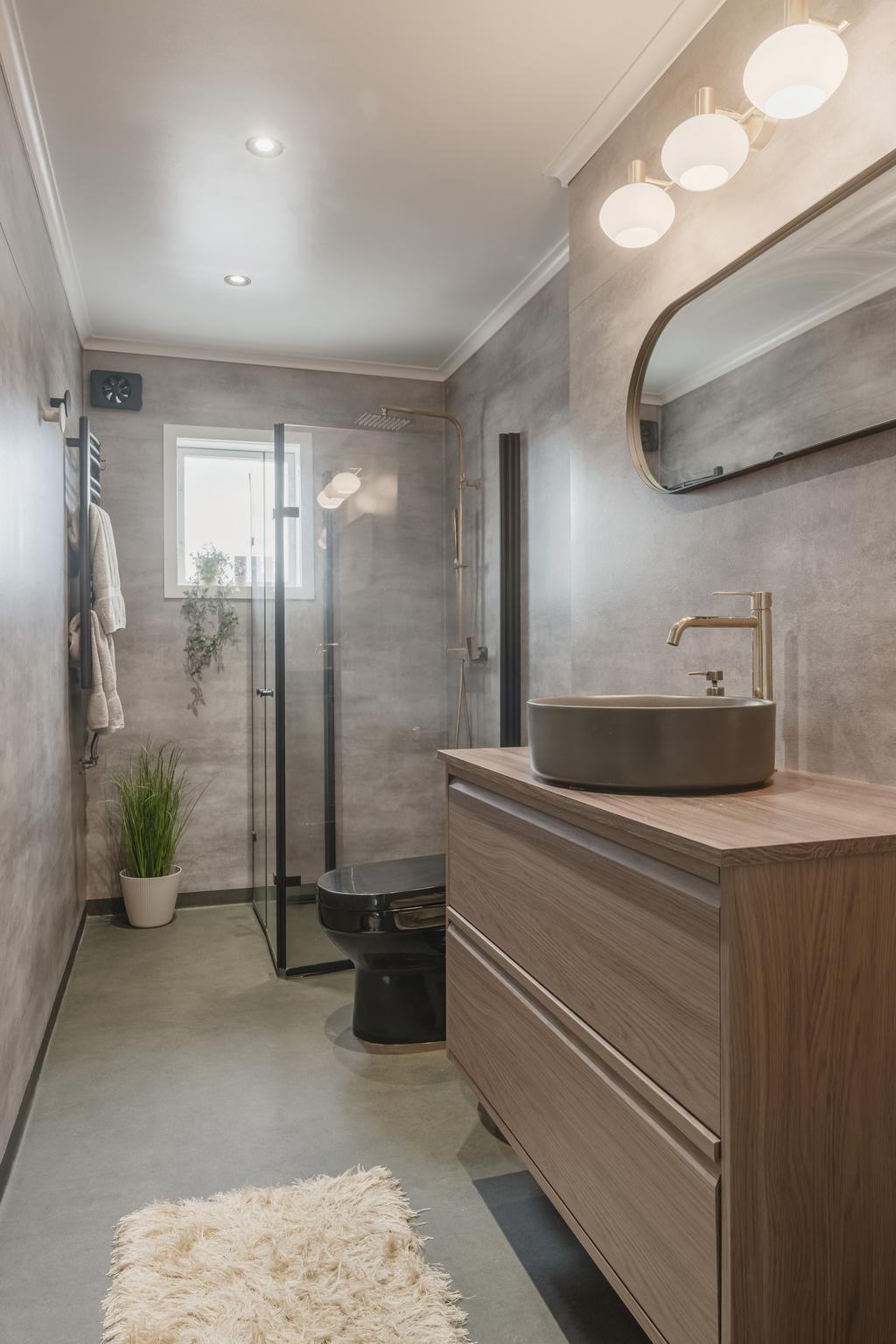 Stilrent och nyrenoverat badrum med moderna materialval, dusch och smakfulla detaljer.