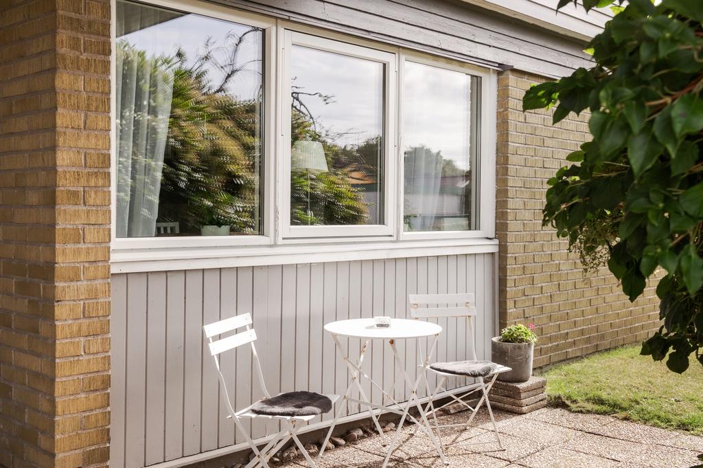 Liten möblerad plats längs husets gavel.