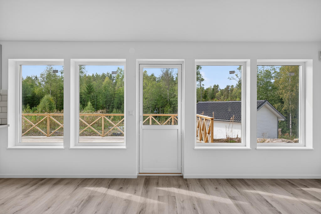 I vardagsrummet öppnar ytan upp med stora fönsterpartier och dörr till den stora altanen på framsidan. 