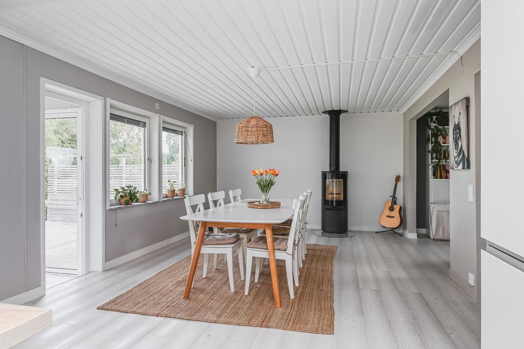 En öppen planlösning mellan kök, matplats och till höger vardagsrummet. Braskamin från 2024, samt direkt access från köket till bostadens fantastiska uterum. 