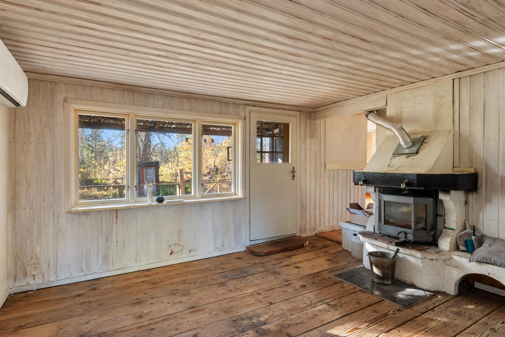 Vardagsrum med öppen spis med insats och luftvärmepump