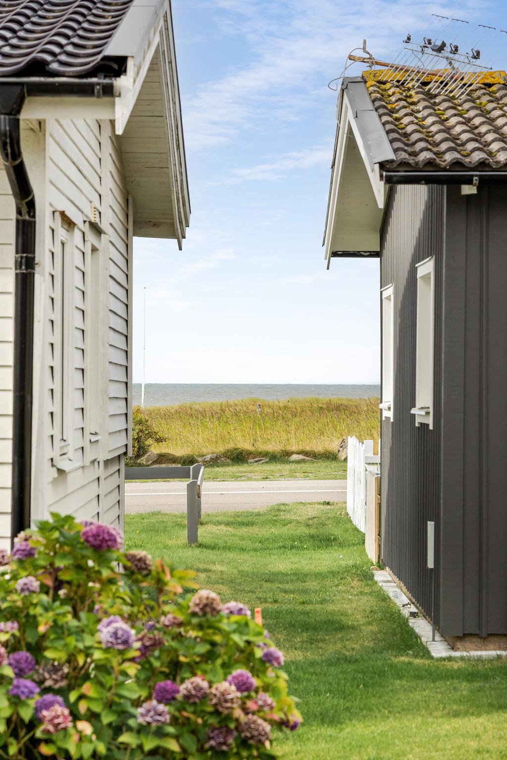 Mellan stugorna öppnar sig vyer mot havet – en tydlig påminnelse om det fantastiska läget. Här bor du med stranden på bekvämt avstånd.