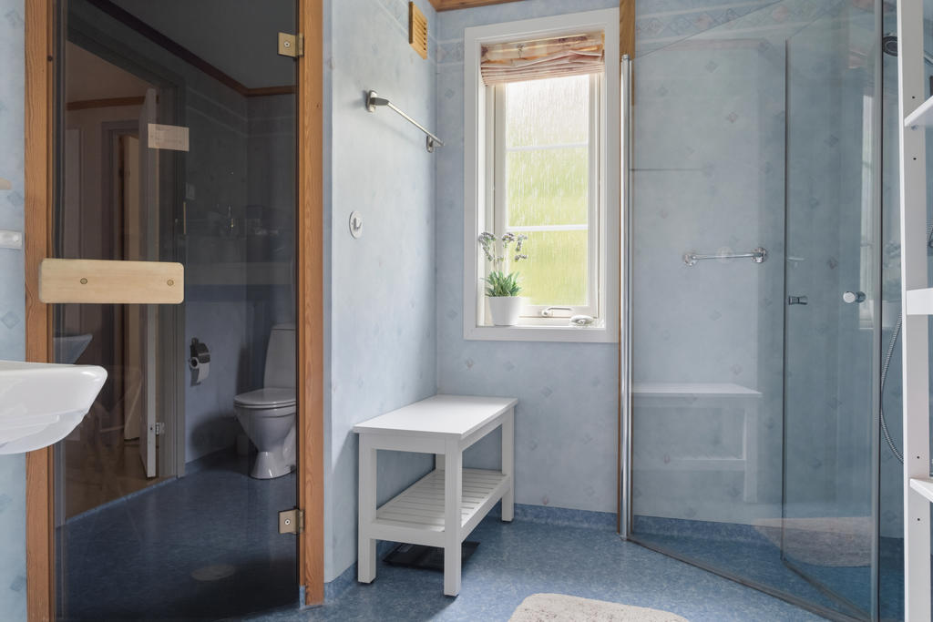 Det större badrummet erbjuder en avkopplande oas med ett elegant badkar och praktisk bastu, kompletterat med wc, handfat och spegel för en komplett spa-upplevelse hemma.