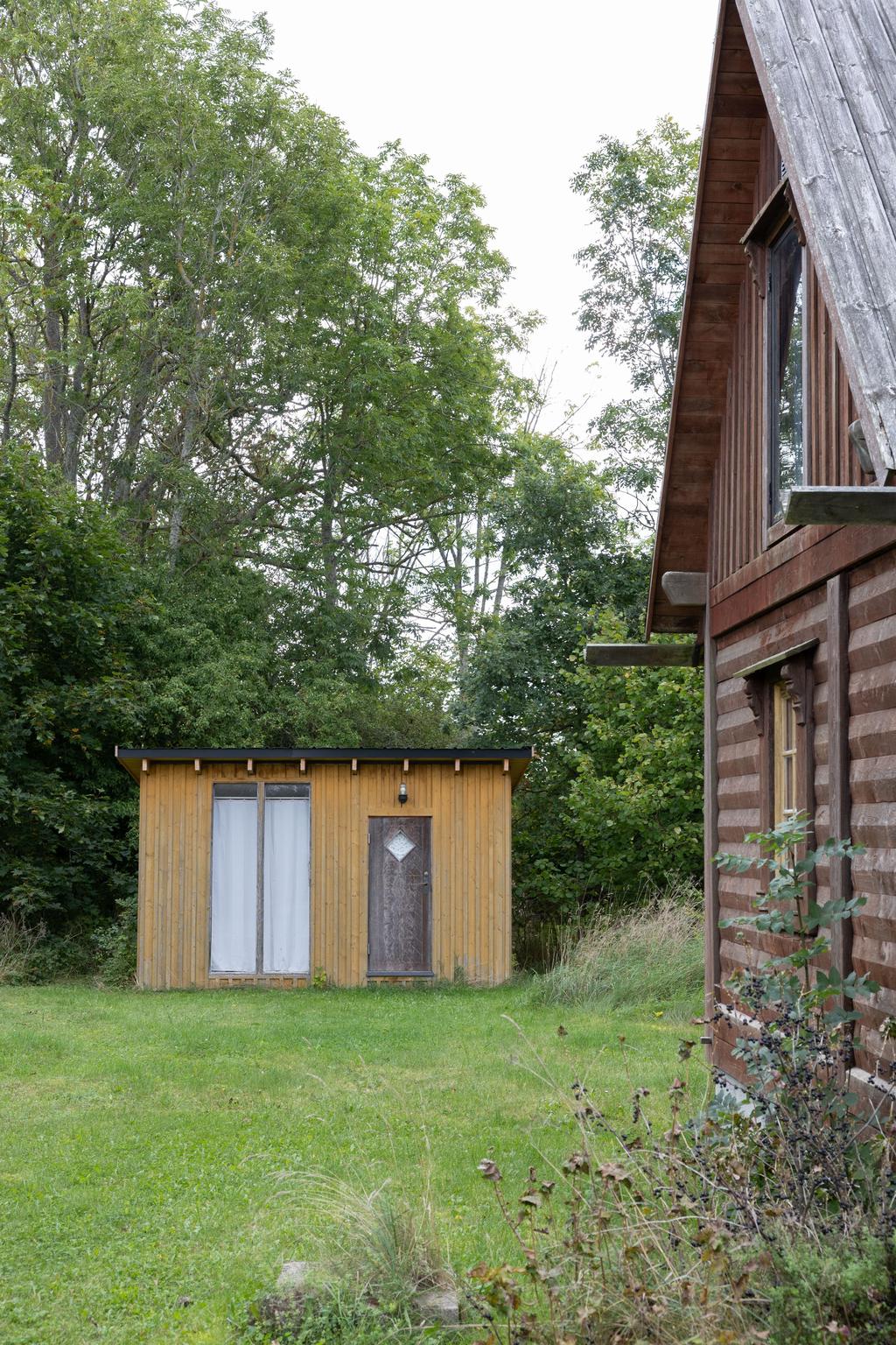 Stuga och toalett hus i bakgrunden
