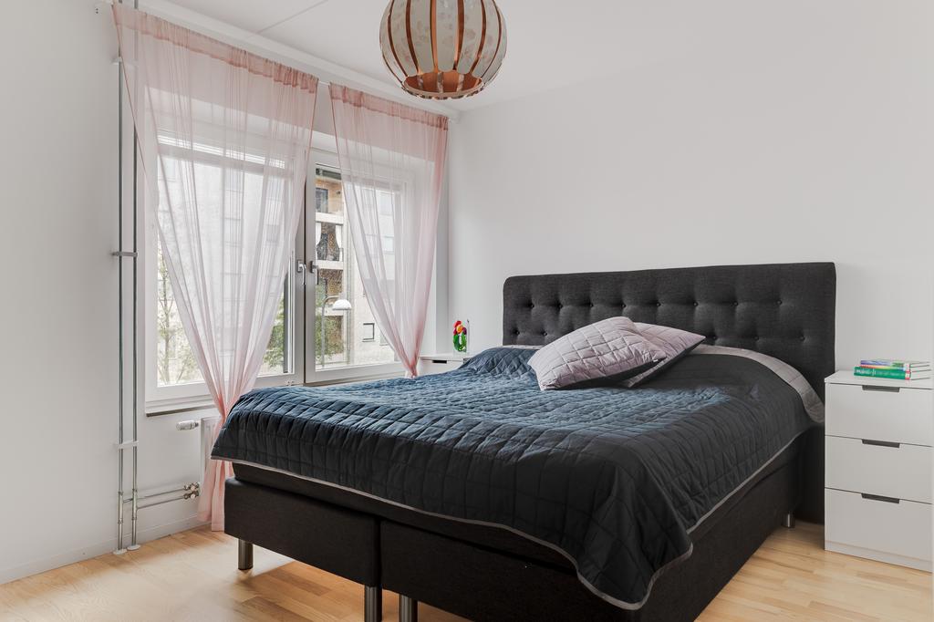 Ljust och rofyllt sovrum med plats för dubbelsäng och förvaring. 
