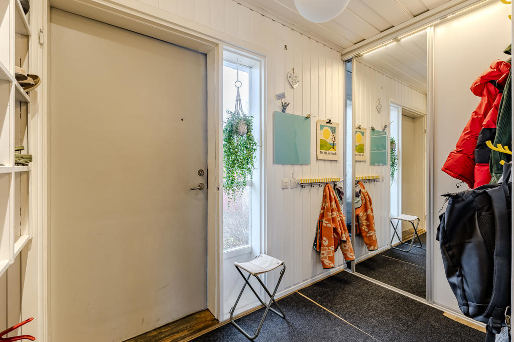 Bra yta för upphängning av kläder och skjutdörrsgarderob i anslutning till entrén