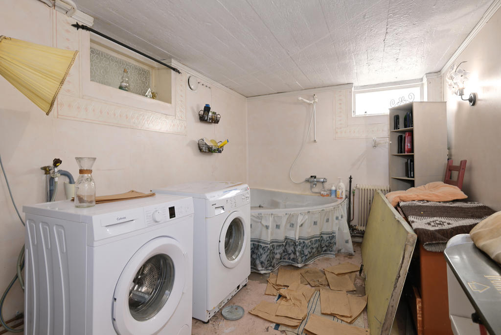 Tvättstuga med badkar i källarplan