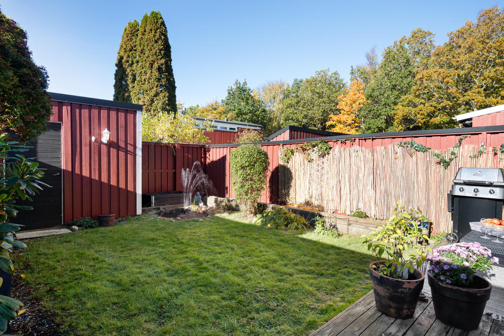 Den skyddade trädgården erbjuder gräsmatta, fina planteringar och gott om plats för både lek och avkoppling.