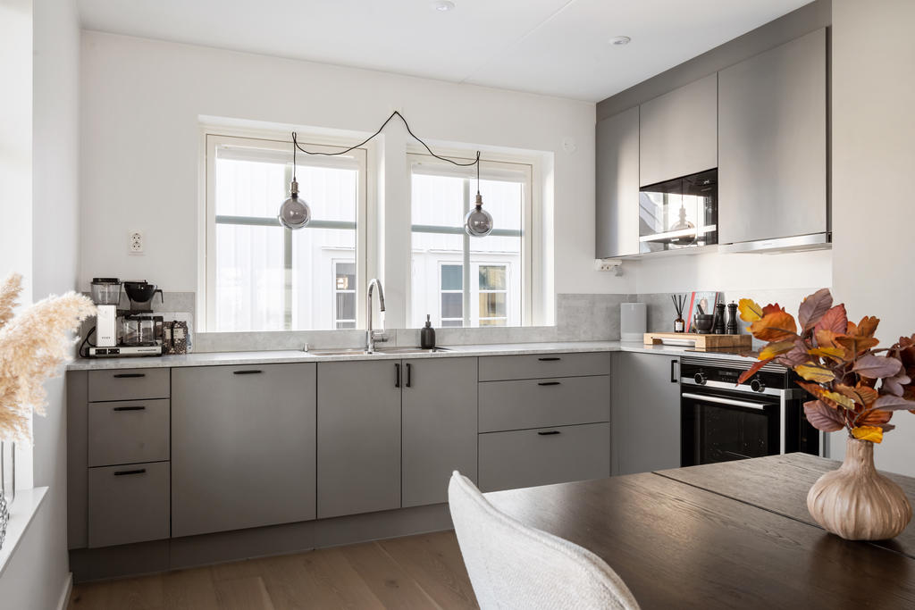 Exklusivt och smakfullt kök från HTH där modern design möter funktionalitet. De stilrena grå köksluckorna harmonierar vackert med den ljusa bänkskivan och de noggrant utvalda detaljerna. Köket erbjuder generösa arbetsytor och moderna vitvaror.